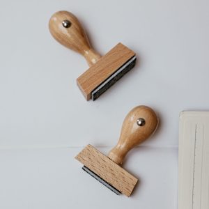 Top view of two wooden rubber stamps and papers, perfect for office themes.